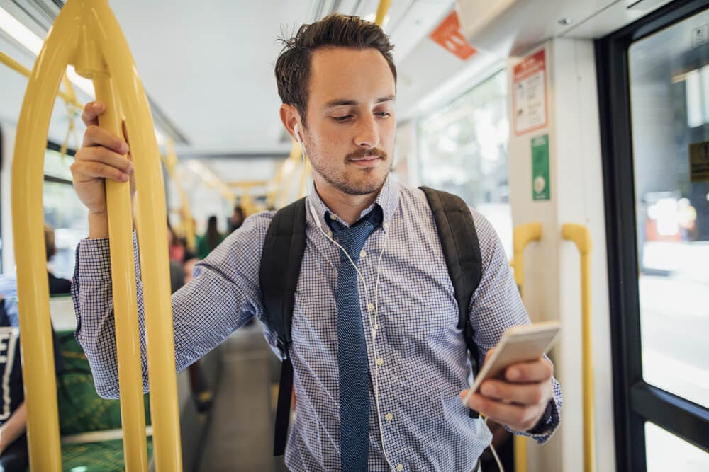 businessman commuting on a train looking at his mobile phone