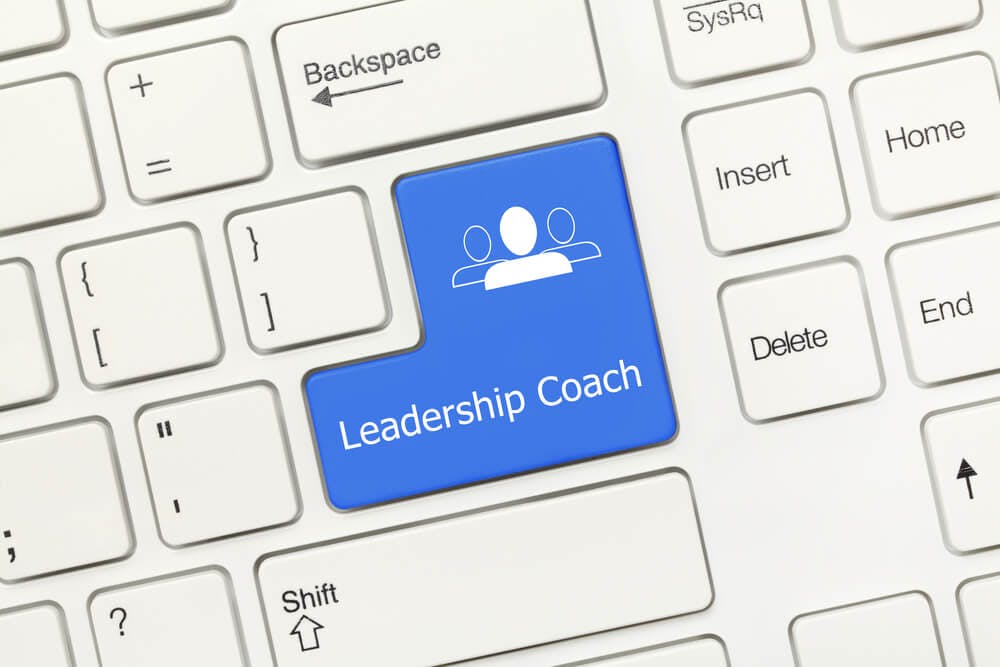closeup of a white keyboard where the enter key is replaced with the words leadership coach