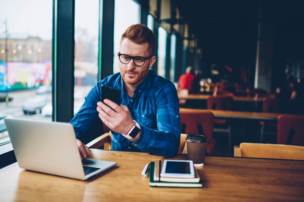 Male learner in a working environment using a laptop for coaching services