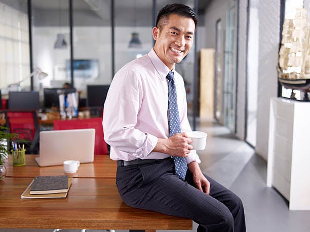 Businessman smiling with a cup in hand