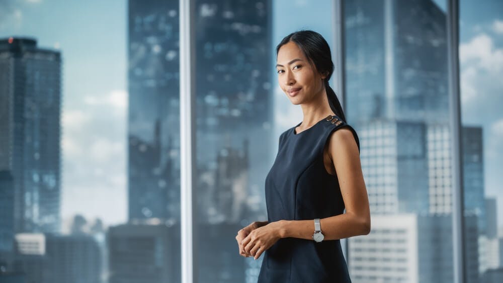 confident businesswoman posing next to a window