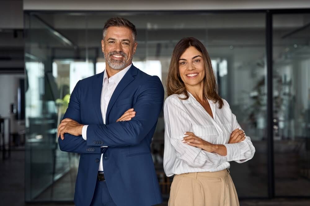 Two coaches standing side by side in a corporate setting