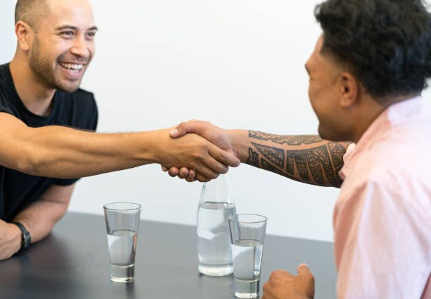 male executive coach and coachee shake hands