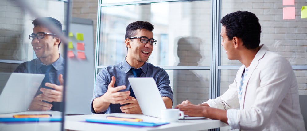 two men talking over in a table