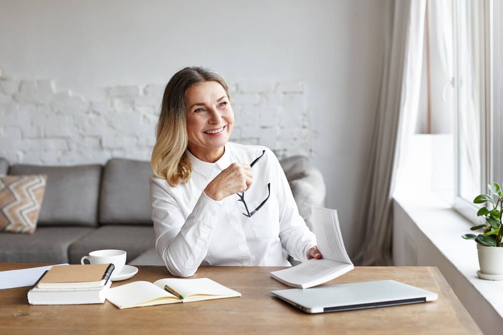 Woman reading books about fixed and growth mindsets
