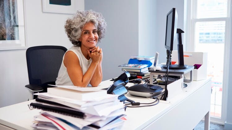 female coach smiling while sitting in her office