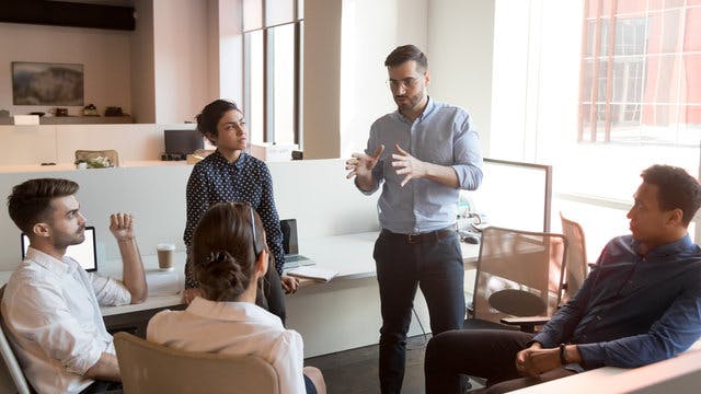 Man standing explaining an idea to interested colleagues