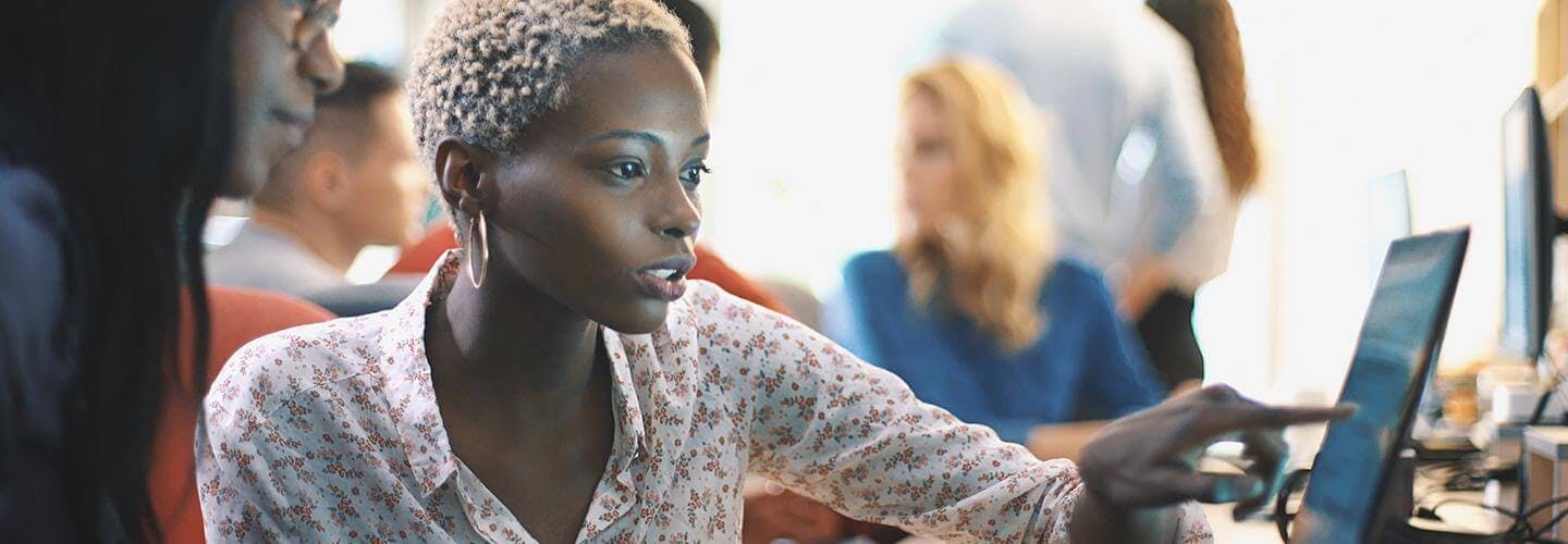 Ladies pointing on computer