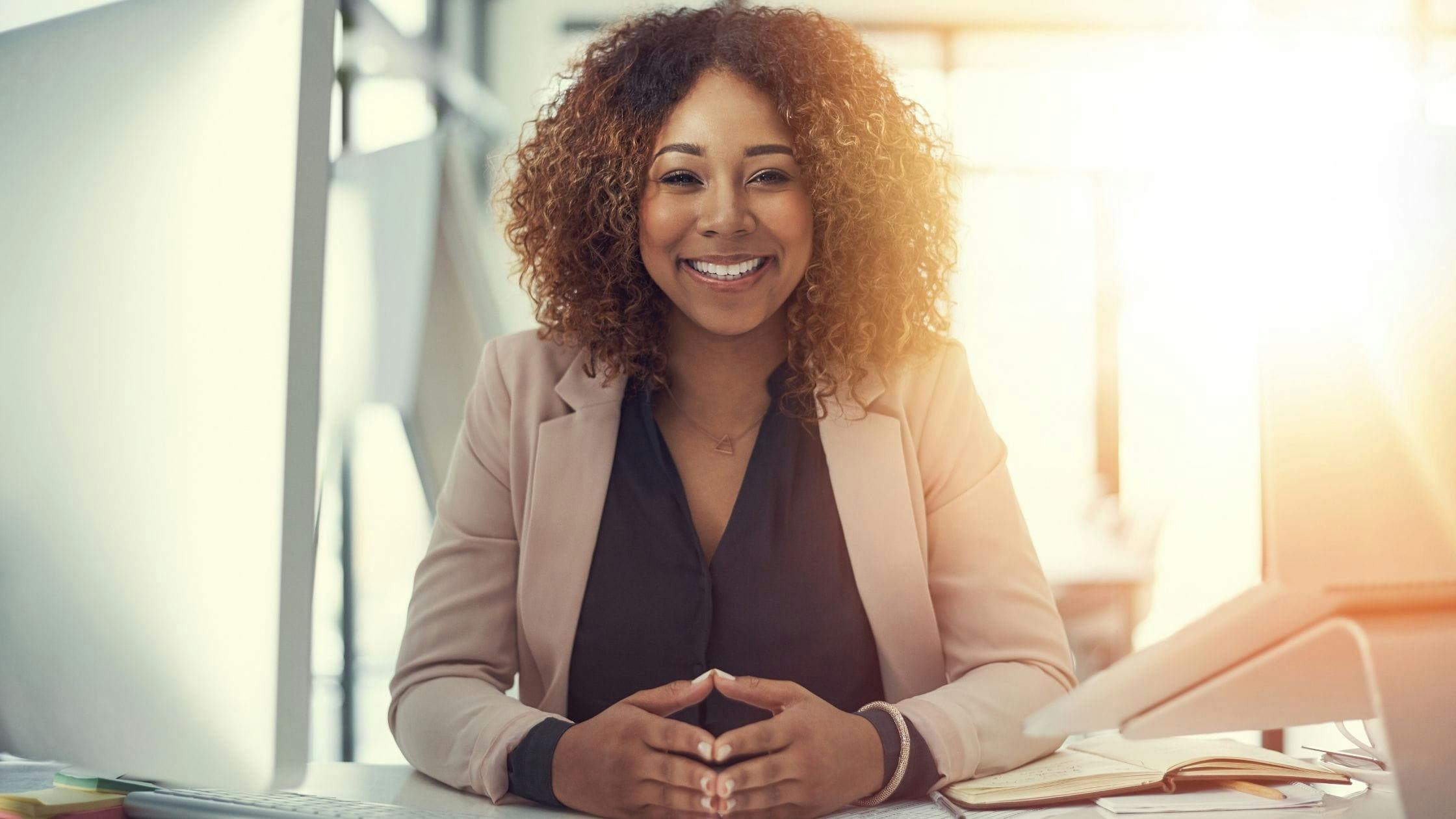 Woman smiling while writing down her personal and professional goals