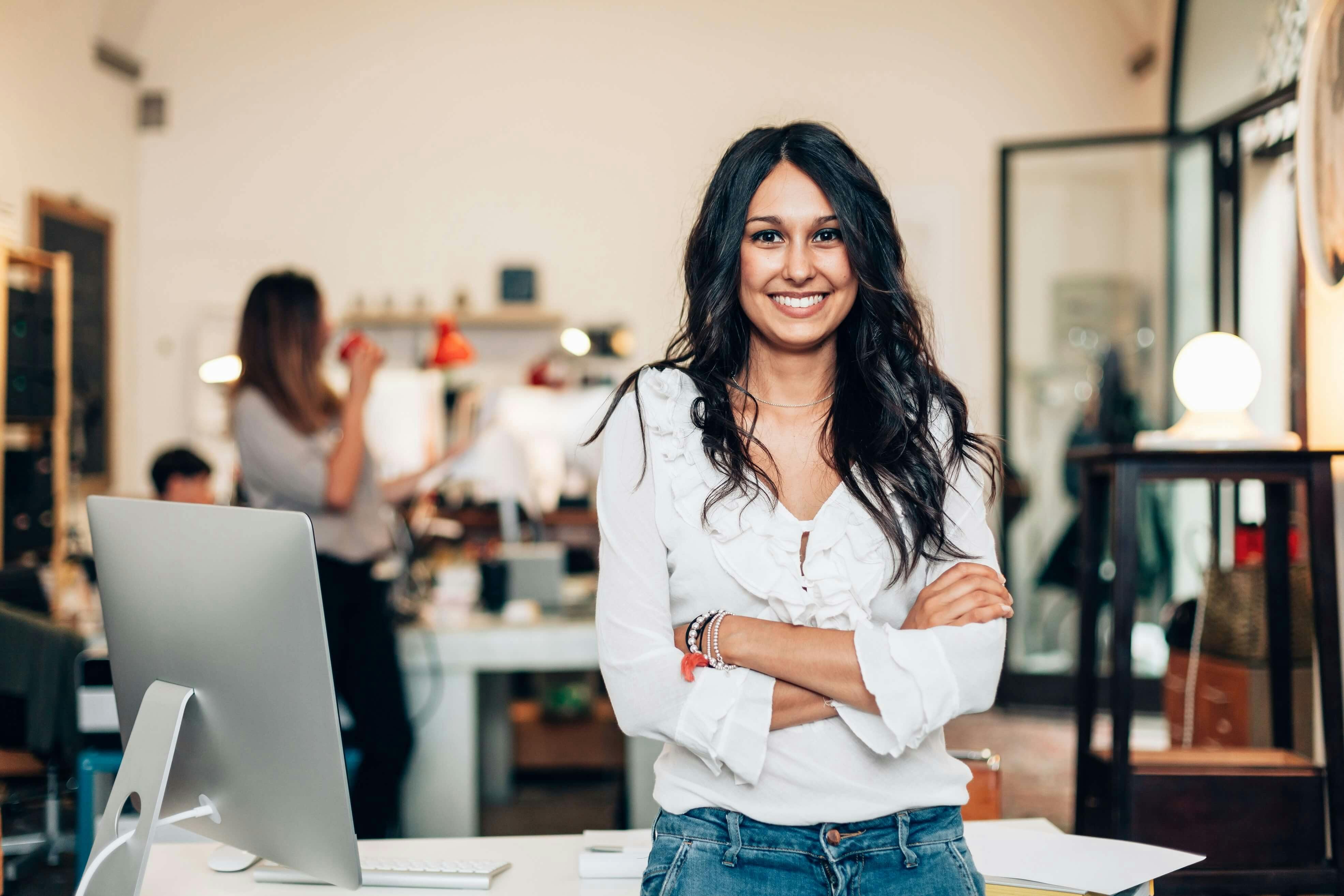 woman in leadership role smiling with arms crossed