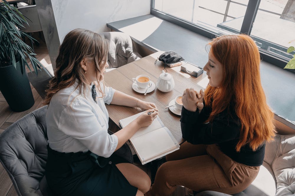 Two women having tea during a relaxed, one-on-one coaching session