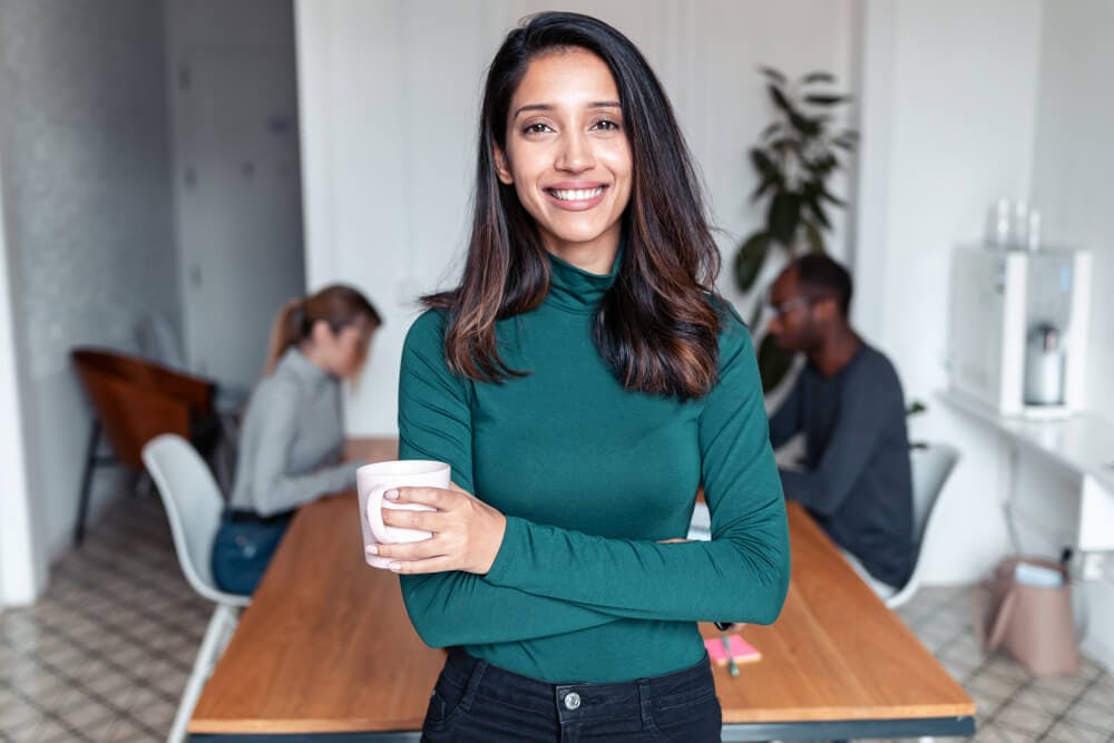 confident young female coach with employees on background