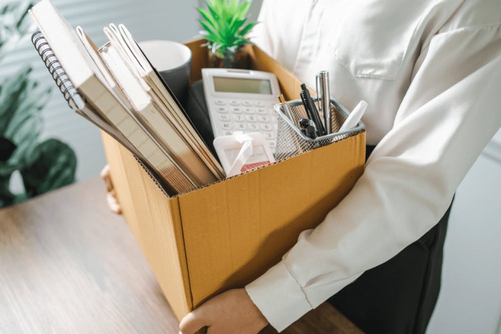 Employee packing things in a cardboard box after getting laid off at work