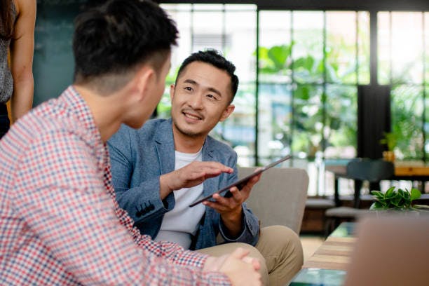 career coach holding a tablet in conversation with an employee