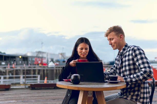 man and a woman talking with each other while drinking coffee