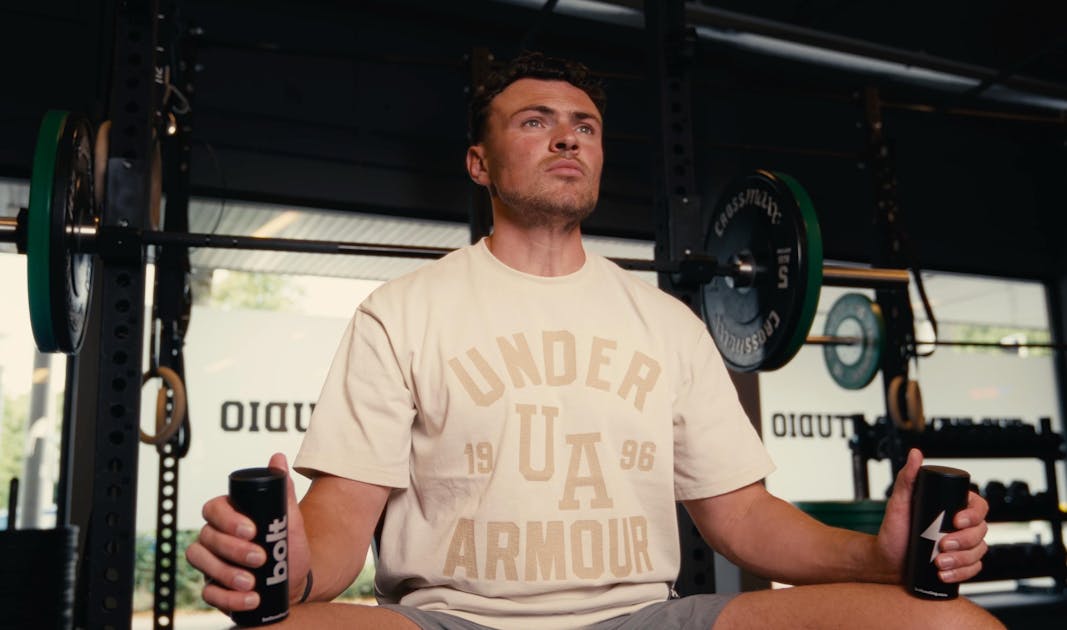 Athlete holding Bolt X1 palm cooling devices in a gym between sets