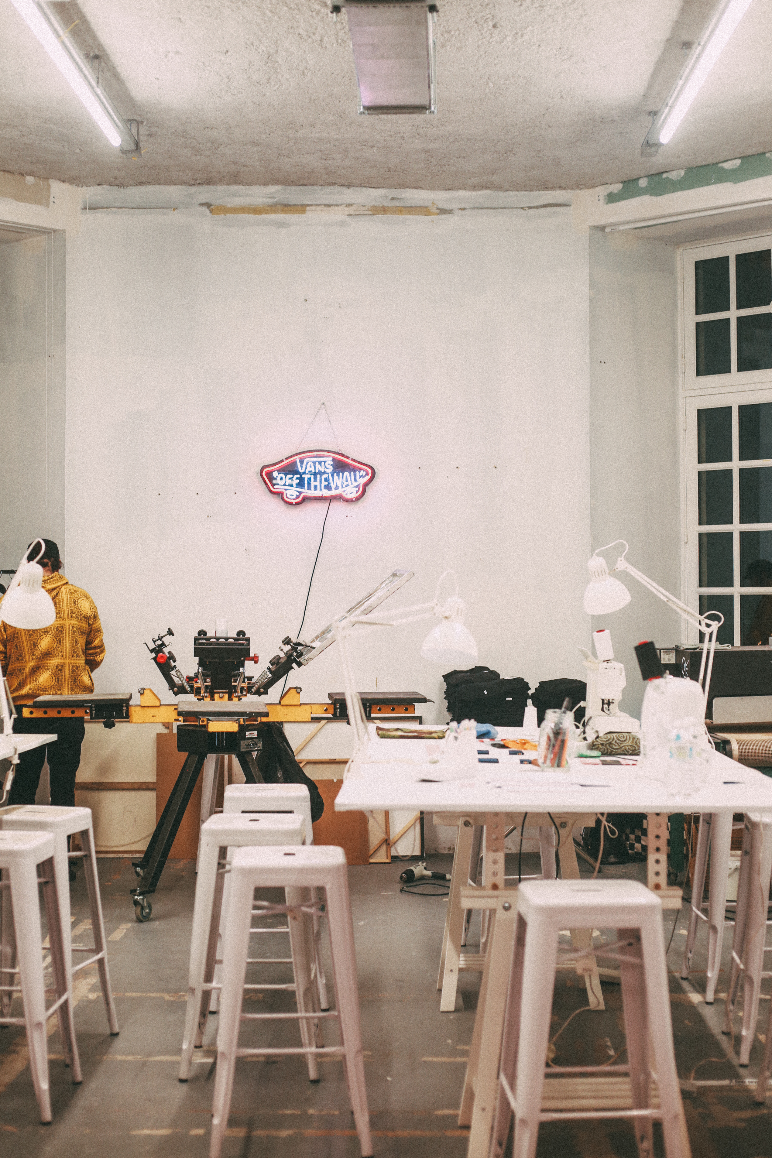 L'atelier upcycling : des grandes tables et des machines à sérigraphie.