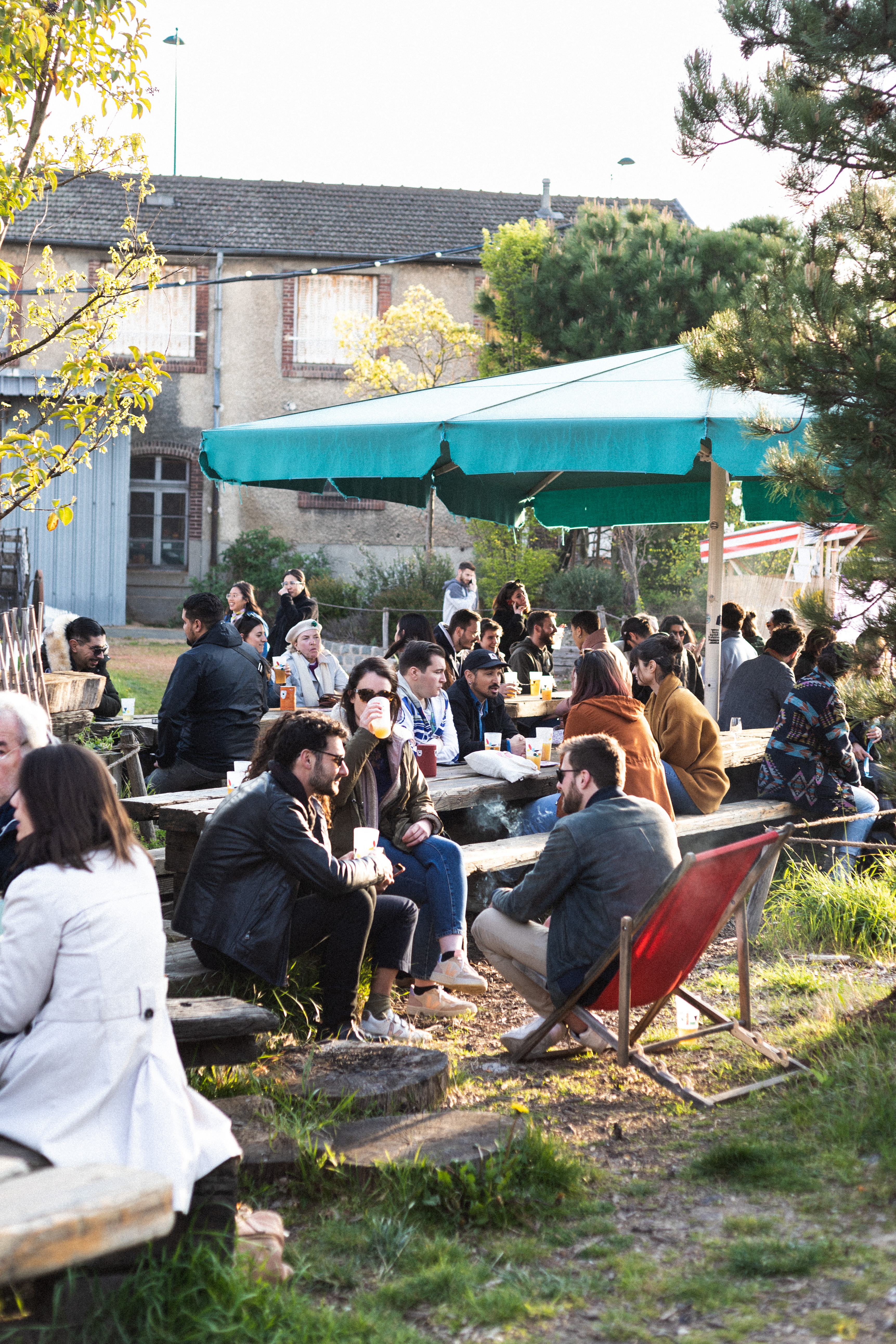 Des gens assis sur des chaises en train de discuter et de prendre le soleil.
