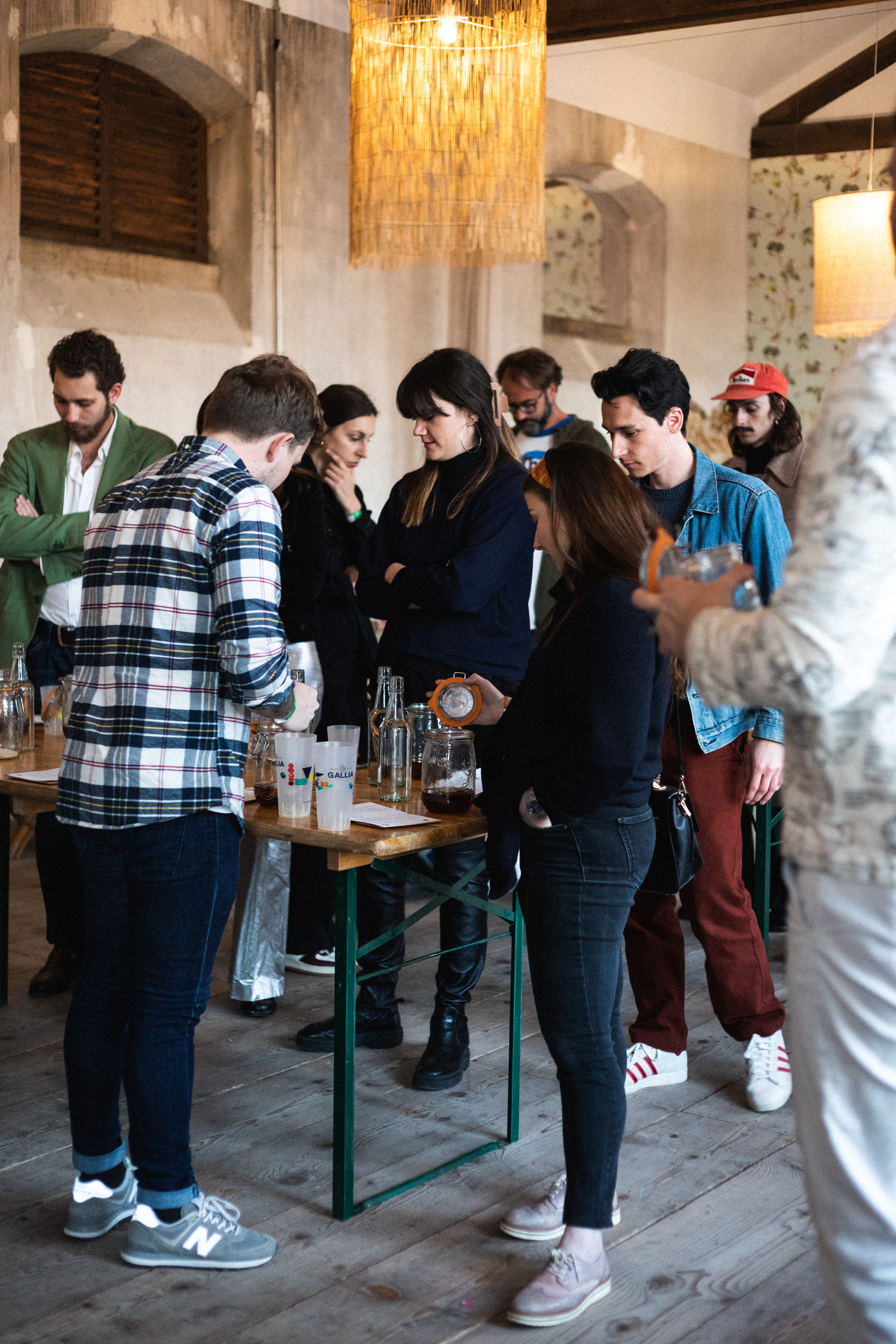Des gens debout autour d'une table en train de se servir quelque chose.
