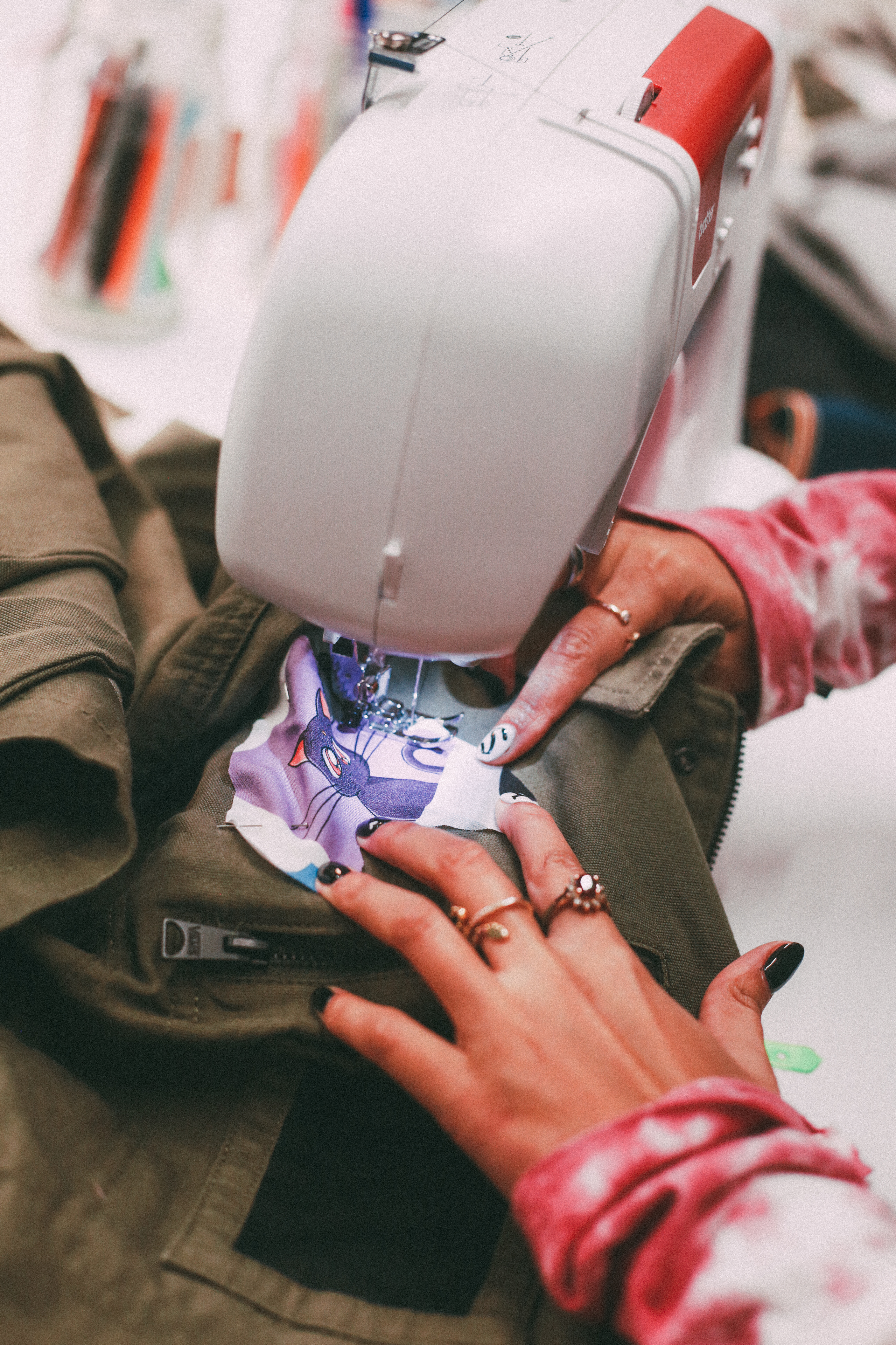 Une personne en train de coudre un patch sur une veste.