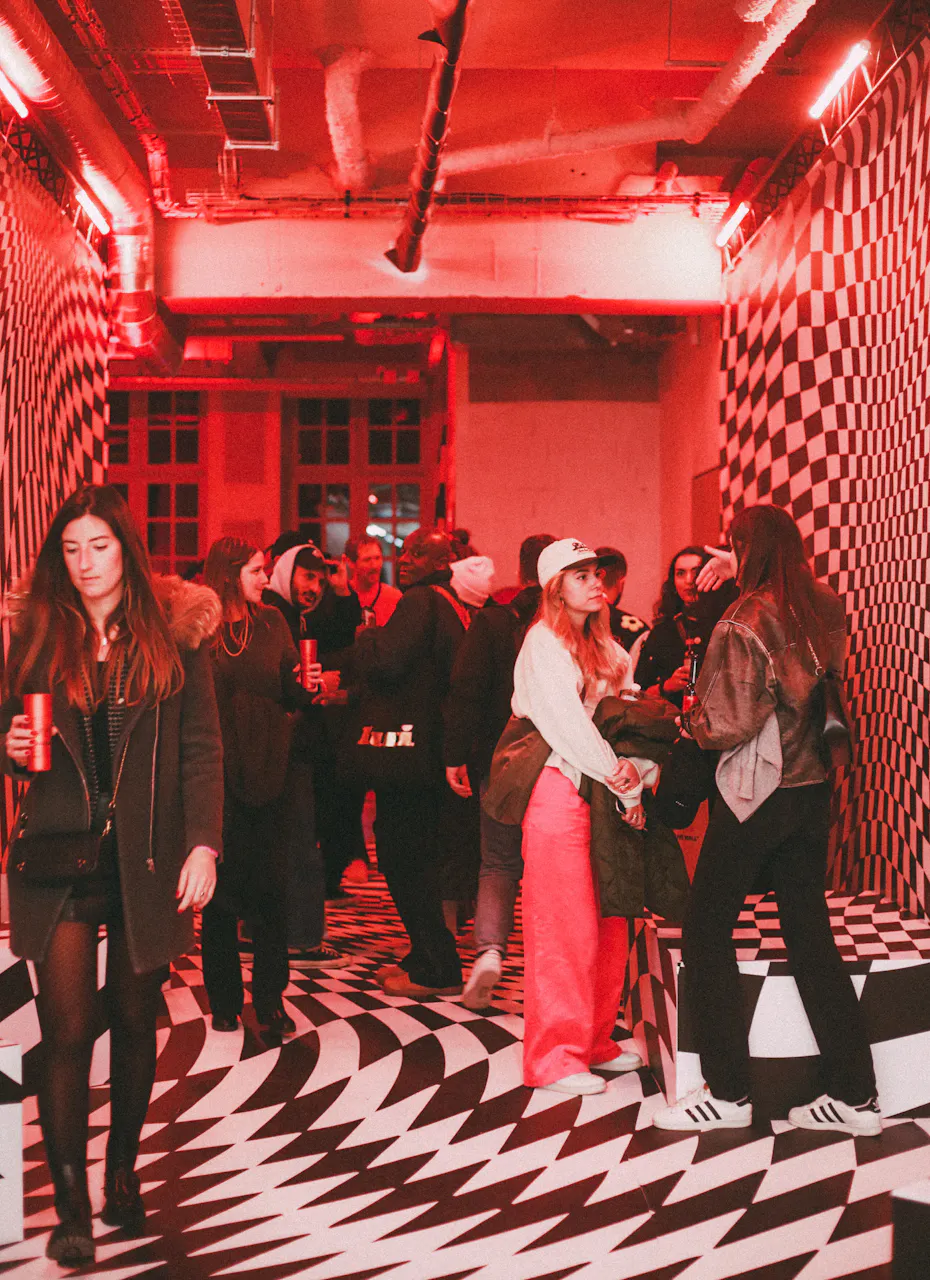 La scénographie du Studio AA : du damier distordu au sol et sur les murs et une lumière rouge.