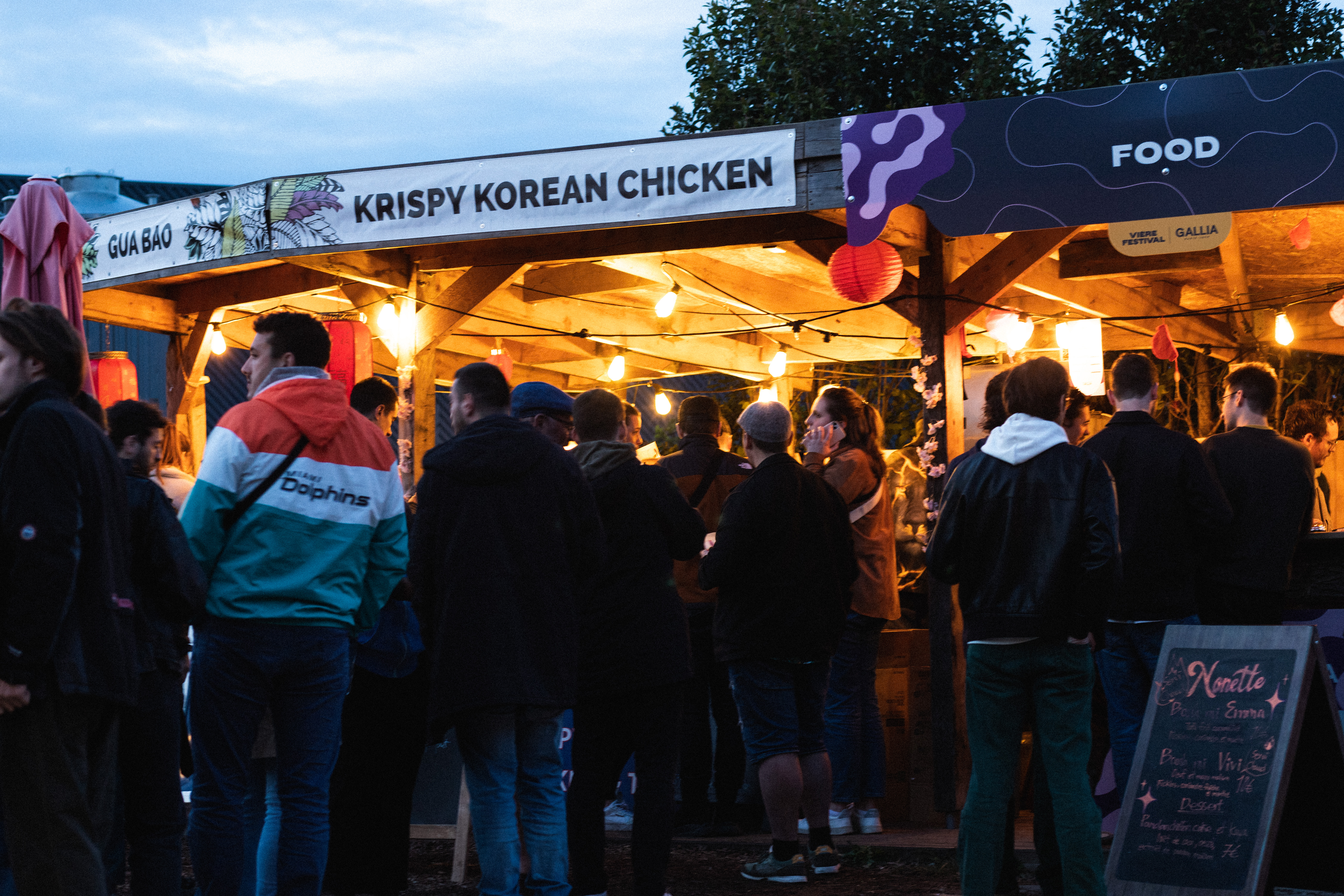 Un stand de Krispy Korean Chicken, avec des gens qui font la queue.