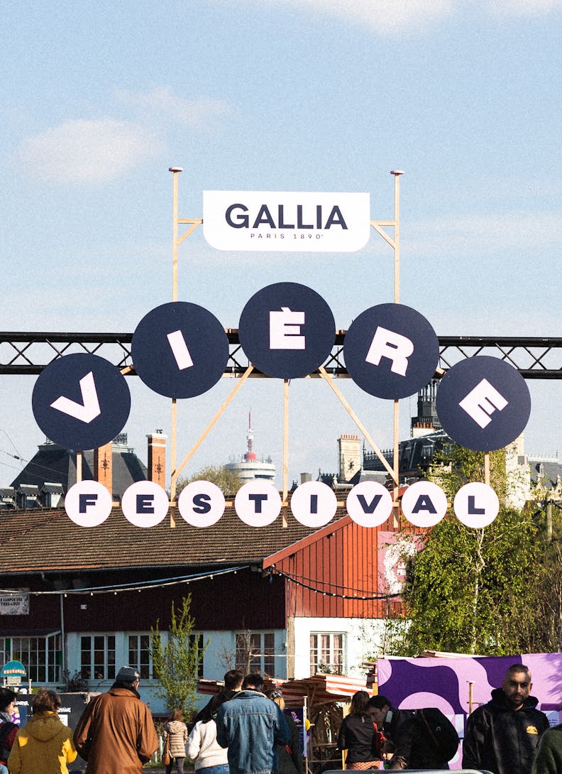 Le panneau à l'entrée du festival. Il est écrit "Gallia Vière Festival" avec une forme ronde pour chaque lettre. 