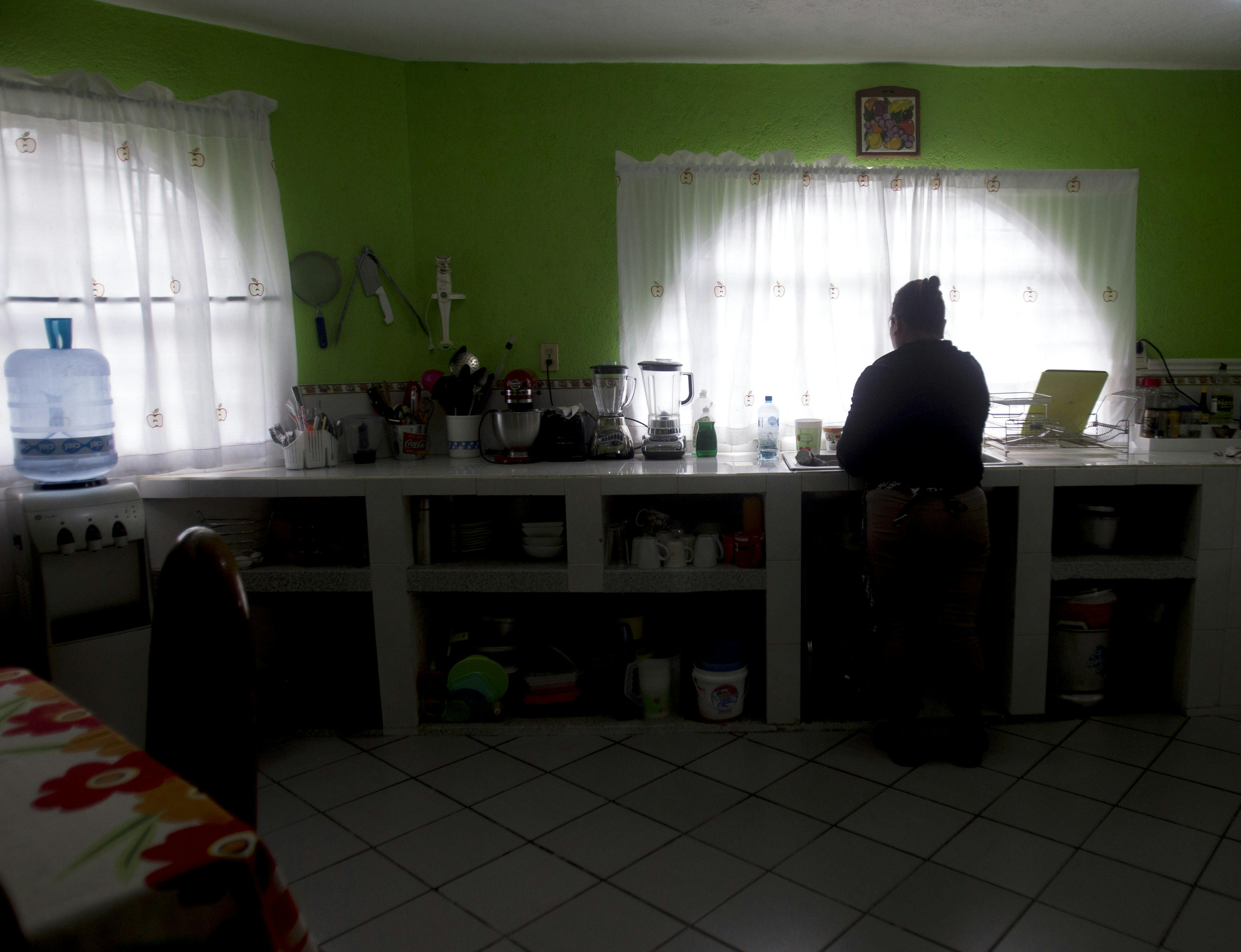 Laura Marín habitante del Barrio de La Cima a espaldas en su cocina