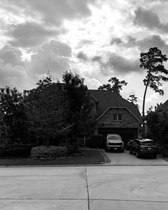 Fotografía de una casa con dos autos al frente