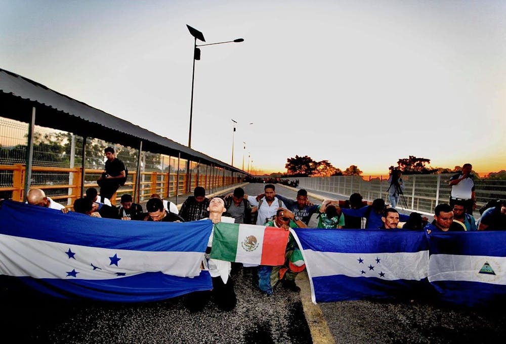 inmigrantes hondureños con banderas de honduras y mexico