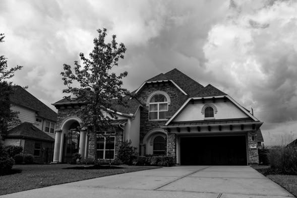 Imagen de una casa con garage y arbol al frente