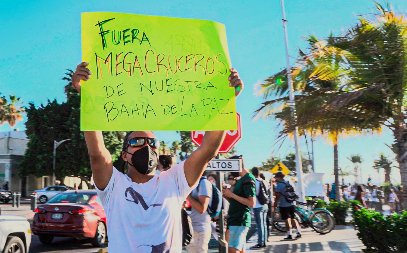 Hombre muestra una pancarta con la leyenda: "fuera megacruceros de nuestra bahía"