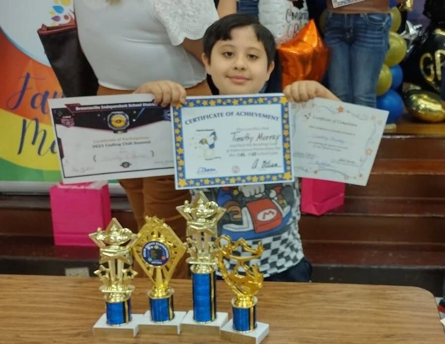 A boy shows diplomas