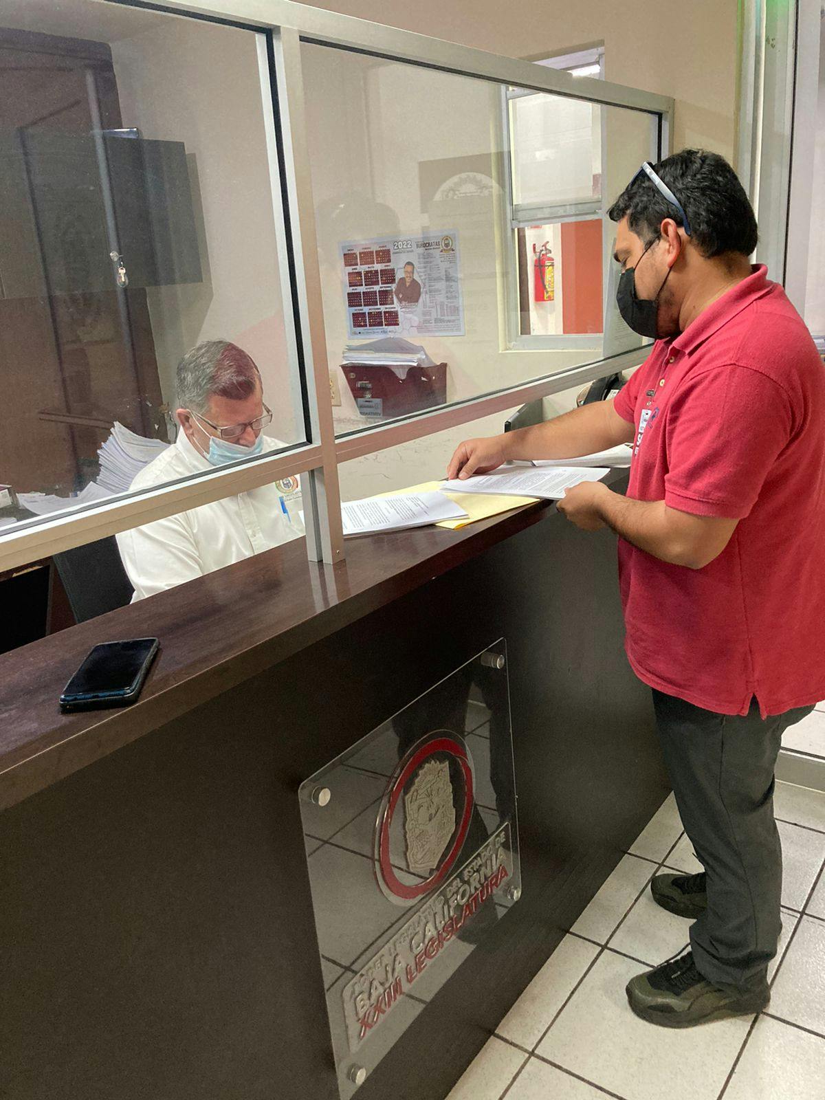 una persona entrega un documento en una oficina de gobierno