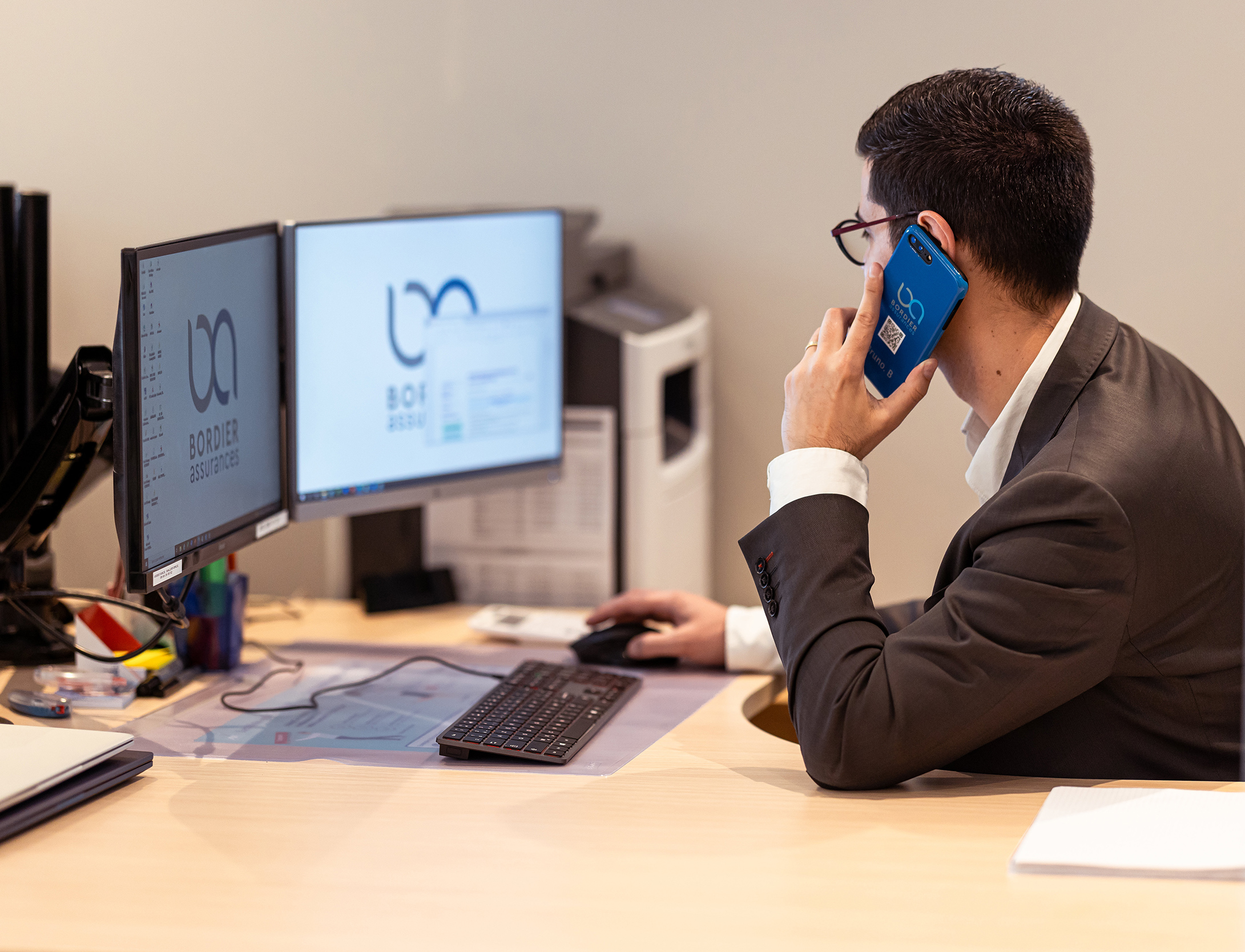 Un employé de Bordier Assurances à son bureau et au téléphone