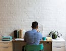 Un homme devant son bureau sur un ordinateur