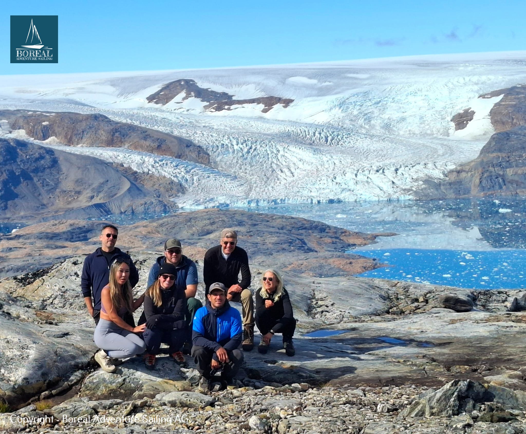 Sail & Explore, East Greenland: guests together on rocks in front of a glacier