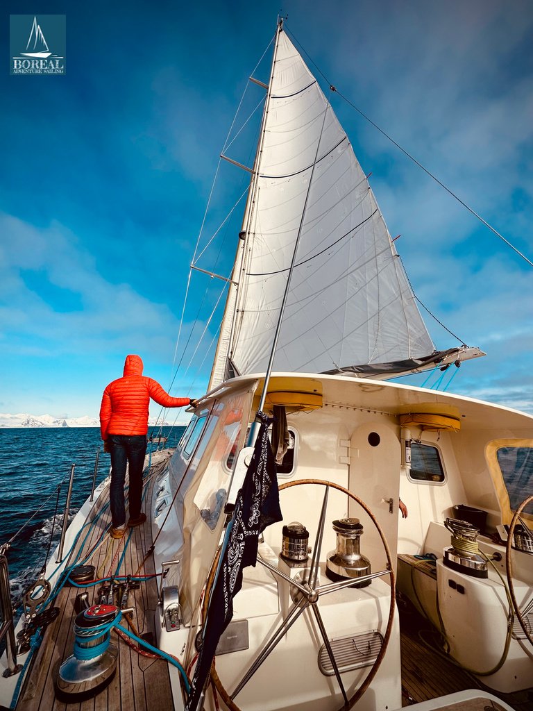Ski & Sail, Svalbard: guest on deck of the yacht under full sail