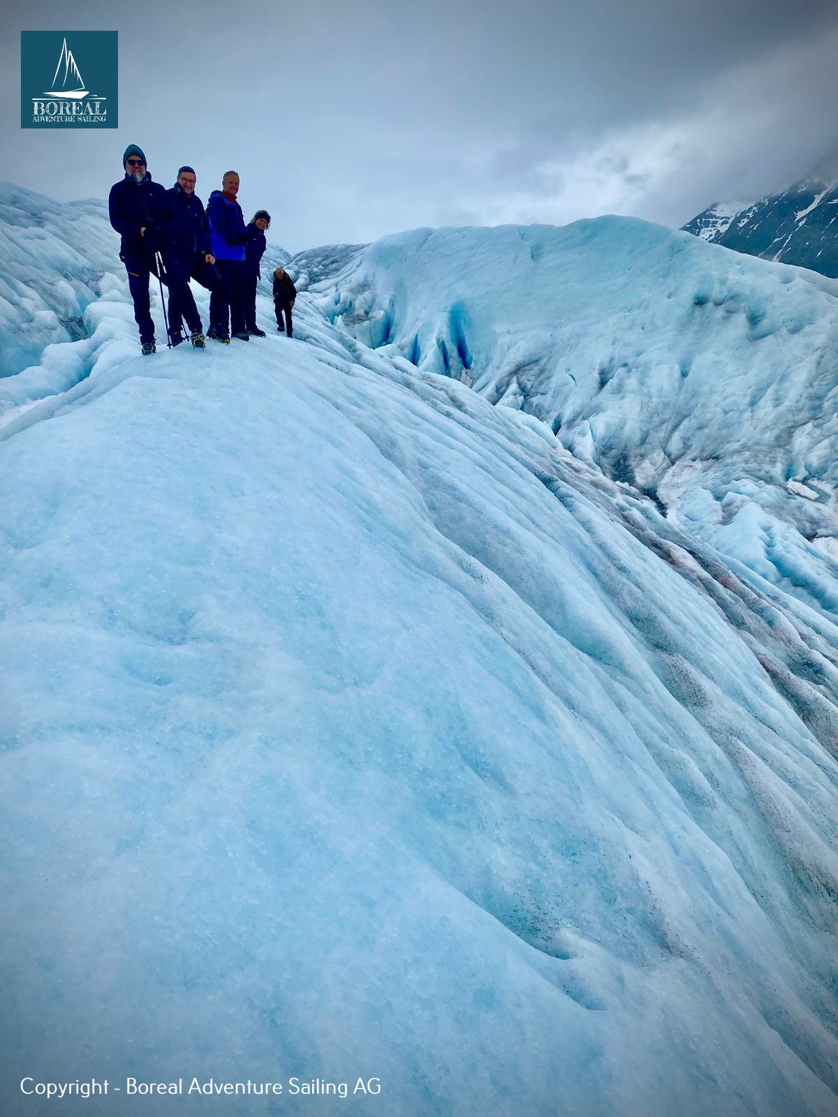 Sail & Explore, Svalbard: hikers standing on a ridge of blue glacier ice