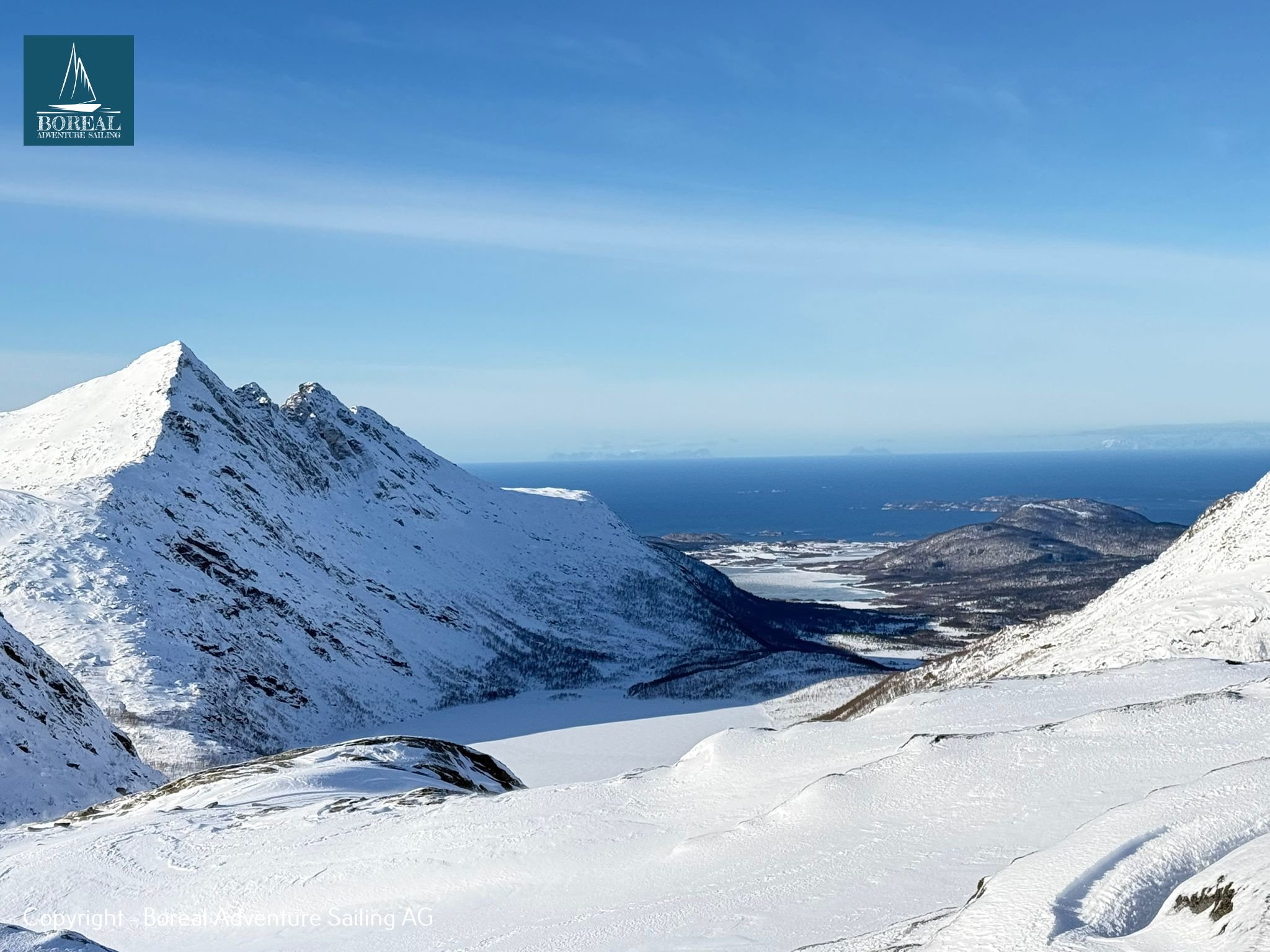 Ski & Sail, Bodø & Lofoten: sharp snowy peak and valley opening onto the sea and islands