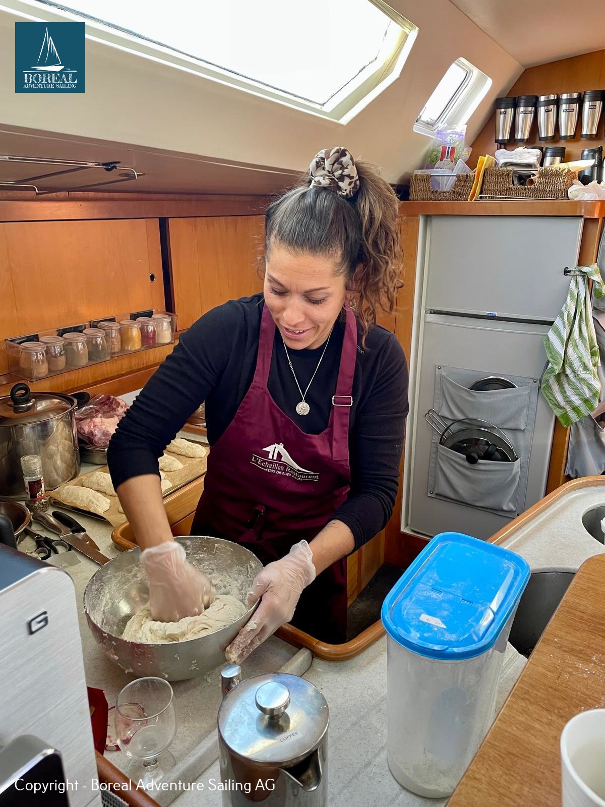 Ski & Sail, Svalbard: cook kneading dough in the yacht's galley