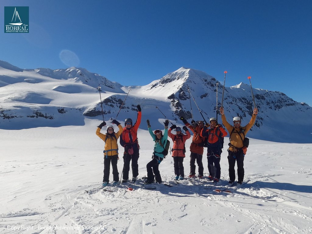 Ski & Sail, Svalbard: ski group celebrating on a summit with arms raised