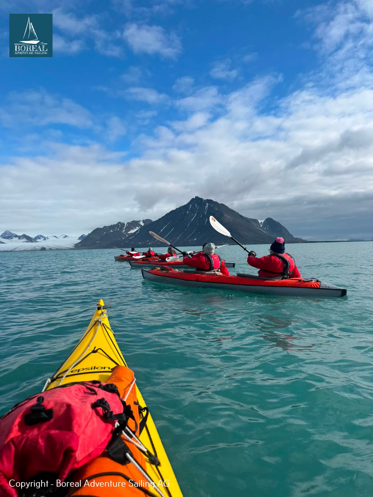 Sail & Kayak, Svalbard: kayak bow following a group of red kayaks on turquoise water