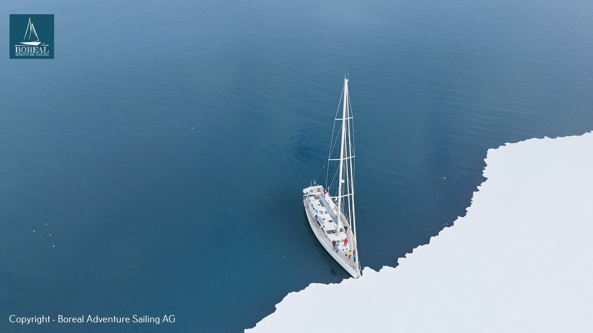 Ski & Sail, Svalbard: drone view of the yacht moored against the sea-ice edge