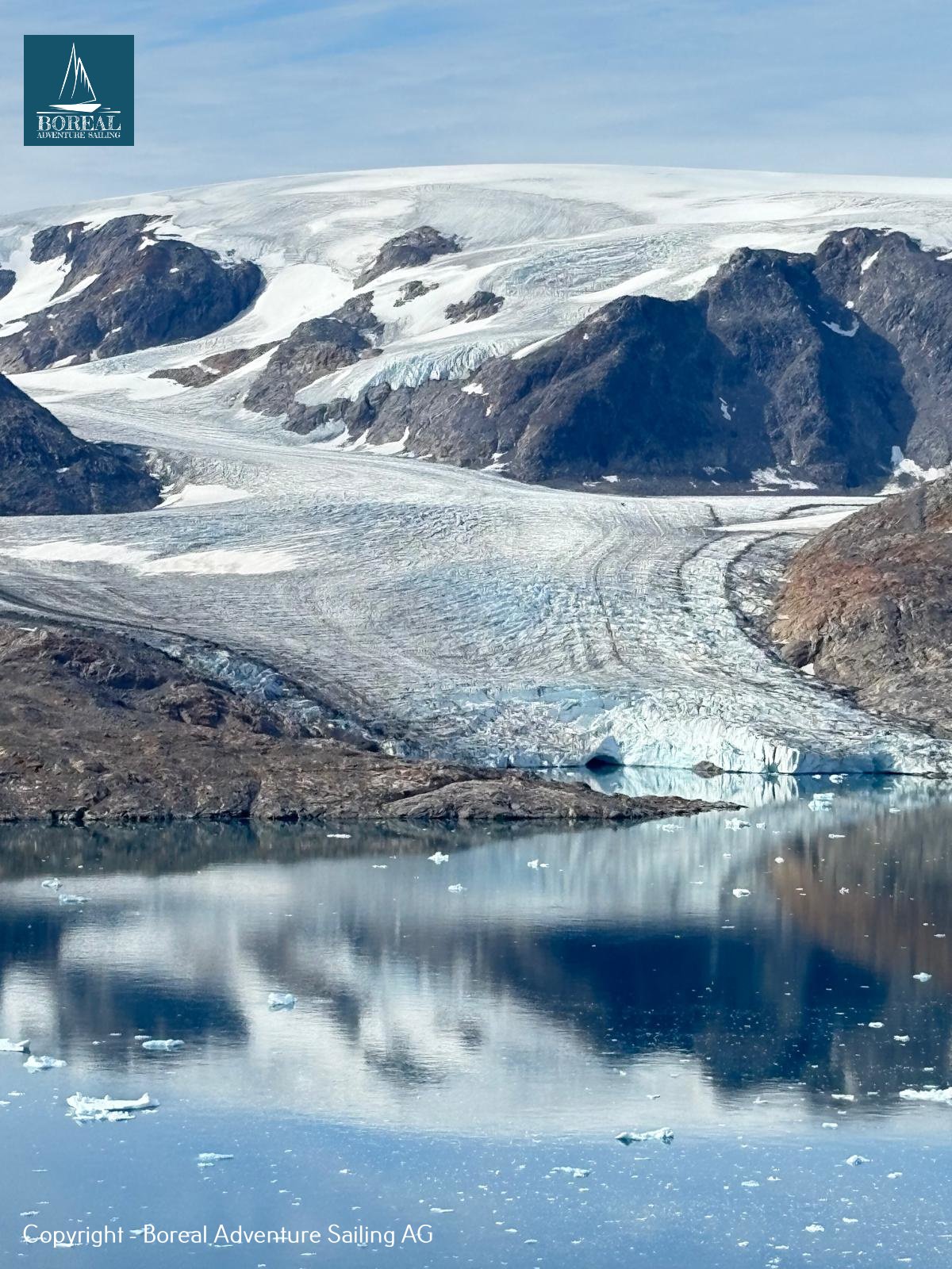 Sail & Explore, East Greenland: glacier tongue and mountains reflected in a still fjord