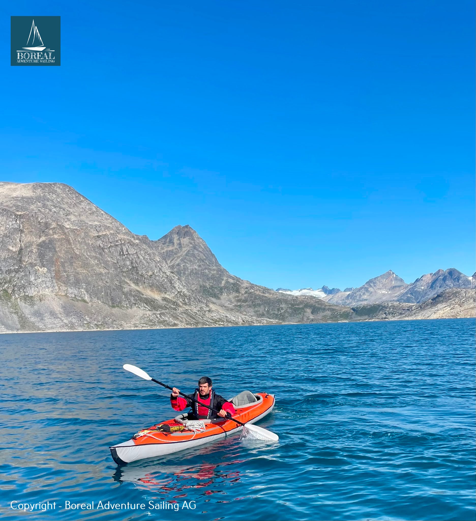 Sail & Kayak, East Greenland: kayaker paddling an orange kayak on a deep-blue Greenland fjord