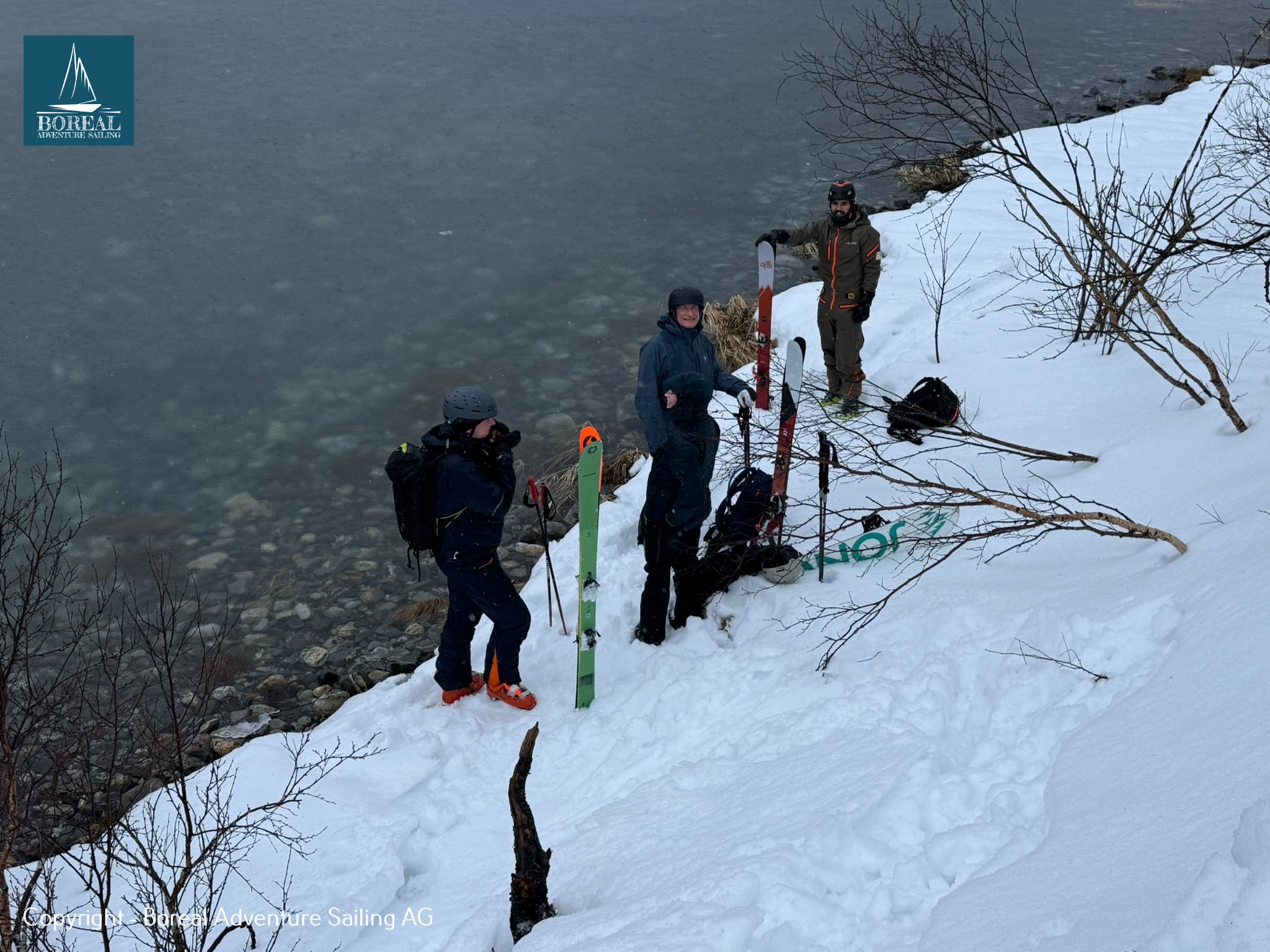 Ski & Sail, Bodø & Lofoten: ski tourers preparing gear on a snowy shoreline beside the fjord