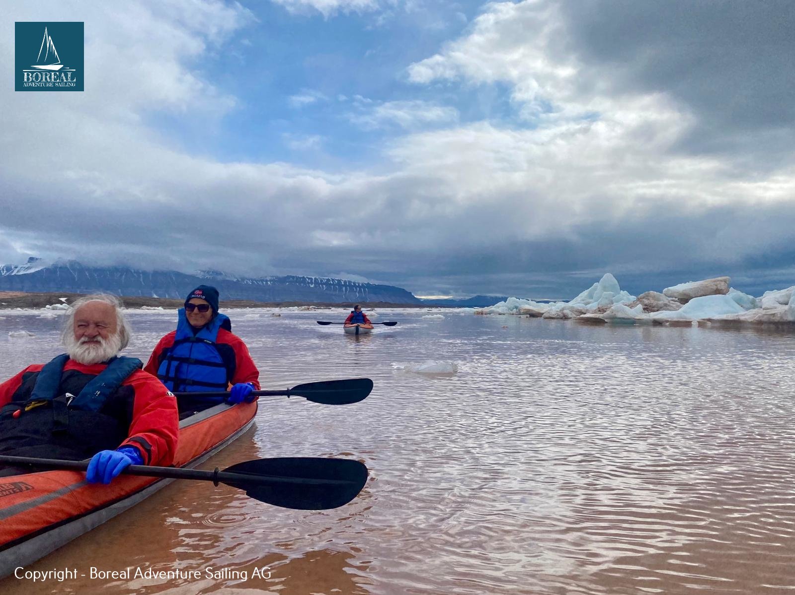 Sail & Kayak, Svalbard: two guests paddling a tandem kayak among floating ice
