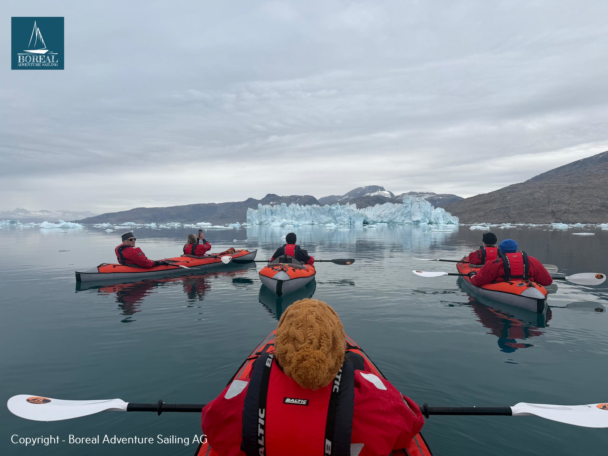 Sail & Kayak, East Greenland: paddler's view of a kayak group heading toward icebergs