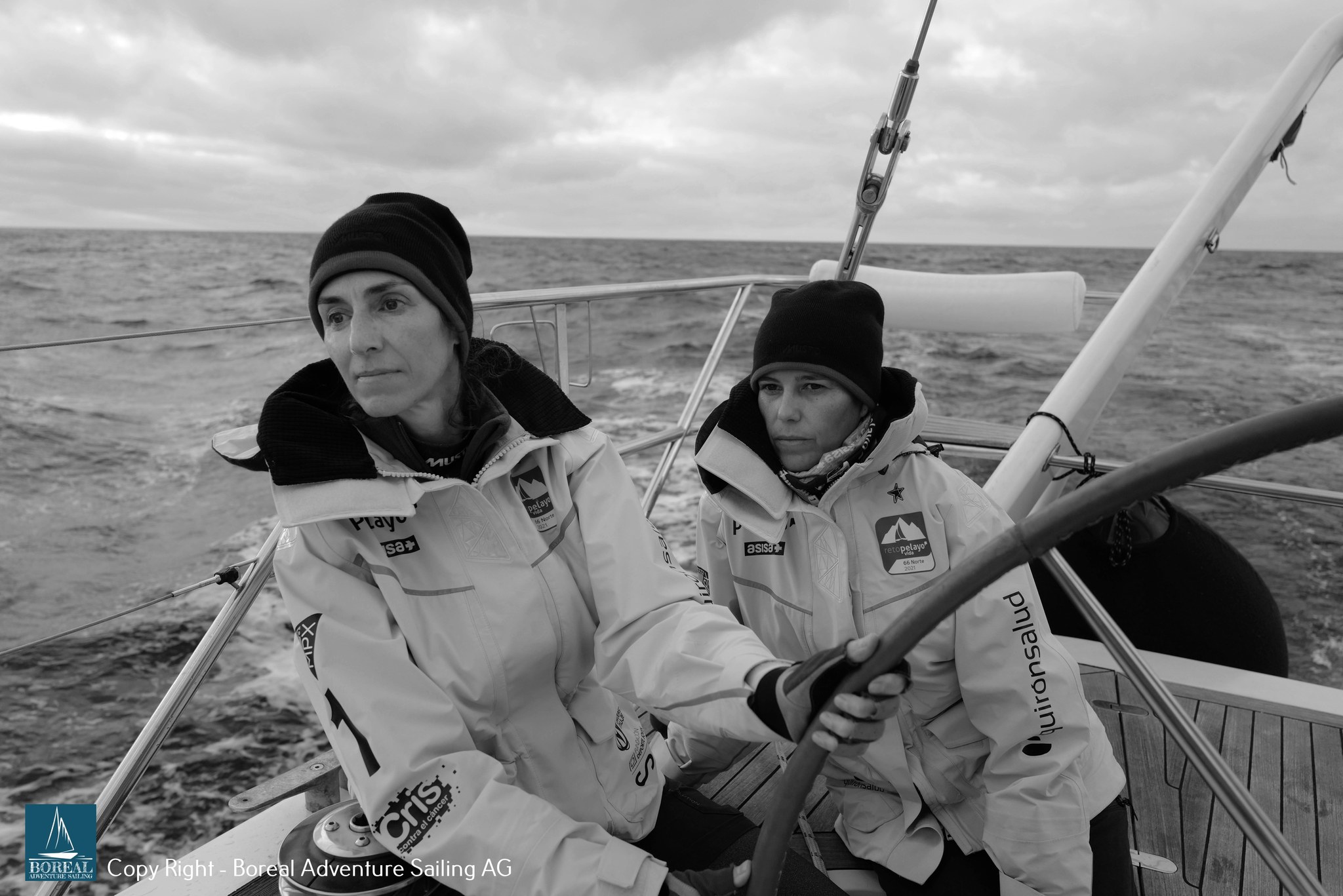 Offshore Sailing: two crew members sharing the helm in heavy-weather gear, in black and white